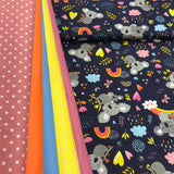 Koalas ar krāsainiem mākoņiem un varavīksnēm uz tumši zila fona