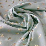Gaiši zaļš poliesters ar ziedlapiņu apdruku